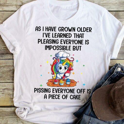 As I Have Grown Older I’ve Learned That Pleasing Everyone Is Impossible But Pissing Everyone Off Is A Piece Of Cake Cartoon Unicorn Making Cake Shirt